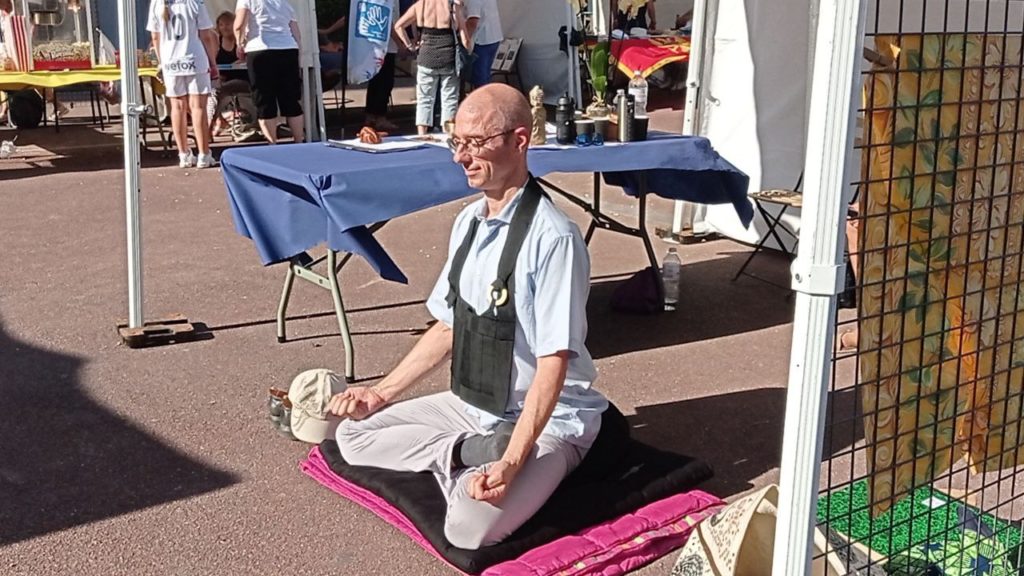 babak seddiq moine zen et enseignant à l'azs93 assis en meditation durant le forum des associations de rosny sous bois 93